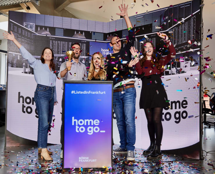 Five people are celebrating an award on a stage.